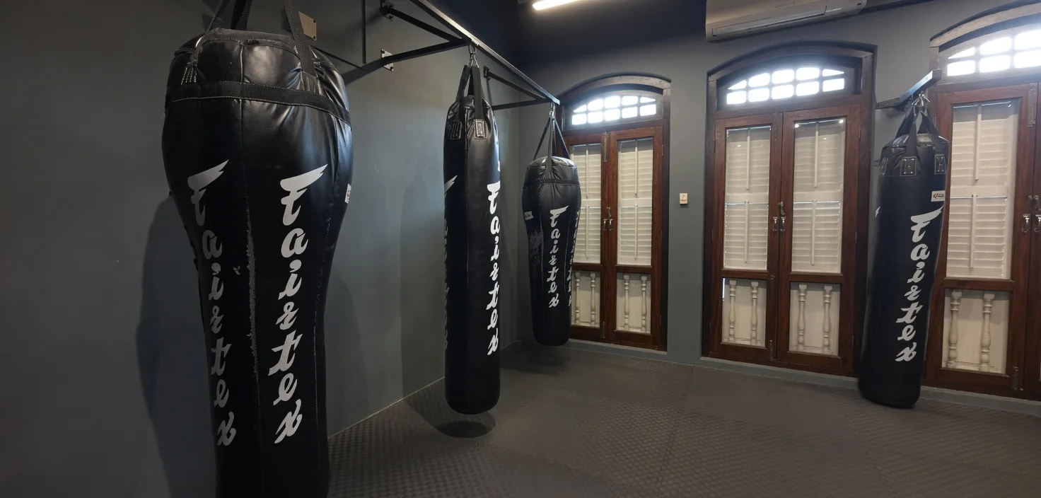 Fairtex heavy bags lining the shophouse windows at Van Lee Fitness